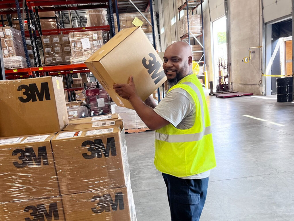 The Will Group employee handles boxes in a warehouse facility