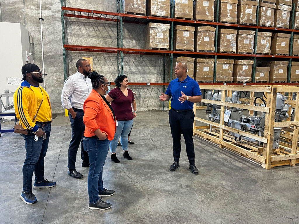 The Will Group team leader addressing a group of people in a warehouse