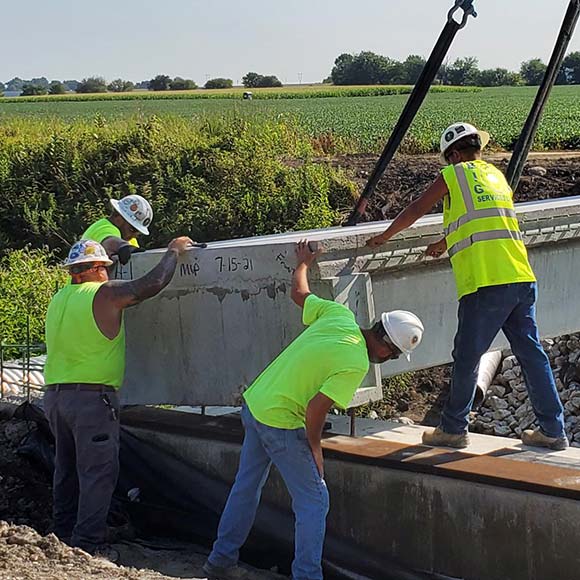 Construction crew members placing a beam on a bridge