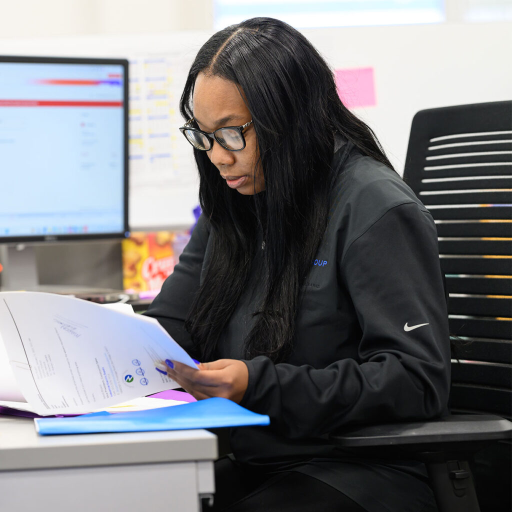 The Will Group employee working on papers at desk